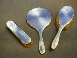 A 3 piece blue enamel and silver dressing table set with hand mirror, hair brush and clothes brush