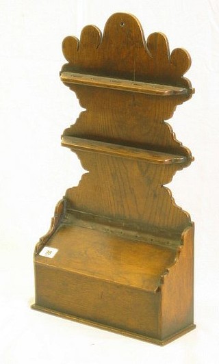 A reproduction 17th Century style oak hanging spoon rack, the base fitted a recess with hinged lid 12"
