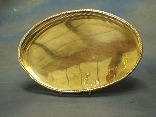 An oval silver plated tea tray with pierced gallery on 3 bun supports 10"