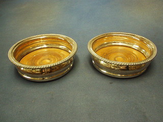 A pair of silver plated wine coasters