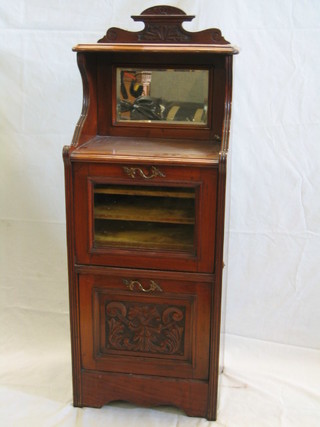 An Edwardian carved walnutwood music cabinet, the upper section of serpentine outline with mirrored back, above a cupboard enclosed by a glazed panelled door, the base fitted a purdonium drawer, 18"