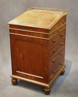 A Regency mahogany Davenport desk with brass three-quarter gallery, having a sliding top with inset tooled leather writing surface, fitted an inkwell and brushing slide above 4 long drawers, raised on bun feet 20" 