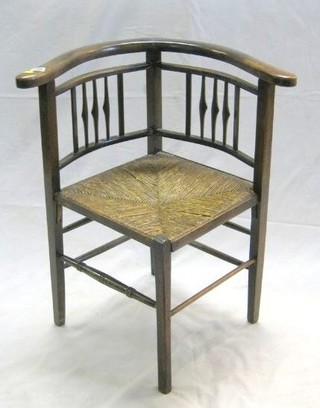 A 19th Century beech corner chair with woven rush seat, on square supports