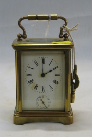 A 19th Century French 8 day carriage/alarm clock with enamelled dial and Roman numerals contained in a gilt metal case