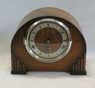 A 1930's chiming mantel clock with silvered chapter ring, contained in an oak arched case