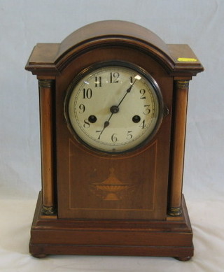 An Edwardian 8 day striking mantel clock with enamelled dial and Arabic numerals contained in an arched inlaid mahogany case