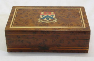 A figured walnutwood cigarette box with ivory line inlay, the lid decorated a college crest, 6"