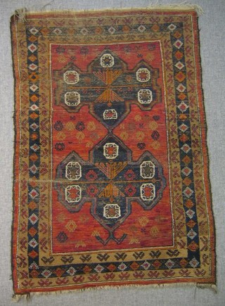 A Turkey red ground rug, decorated 2 guls to the centre within multi row border, 47" x 31"