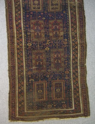 An Eastern rug with 8 rectangular fields to the centre within multi-row border 64" x 34"