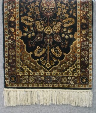 A fine quality black silk prayer rug  decorated a vase of flowers 29" x 22"
