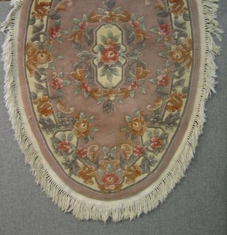 A peach ground oval Chinese rug with floral decoration 60" 
