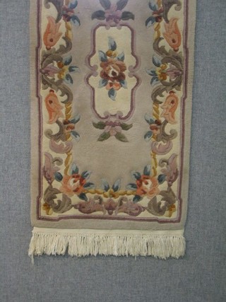 A peach ground floral patterned Chinese rug 49" x 25"