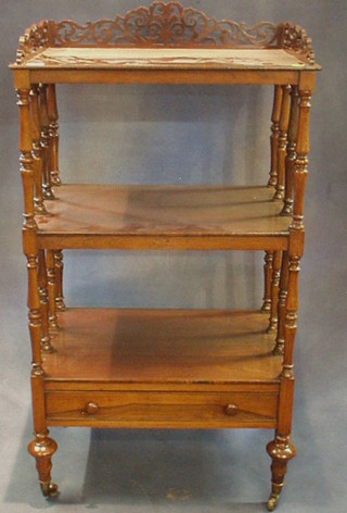 A Victorian rosewood 3 tier what-not with pierced three-quarter gallery, raised on turned columns, the base fitted a drawer and raised on bun feet, ending in brass caps and castors 24"