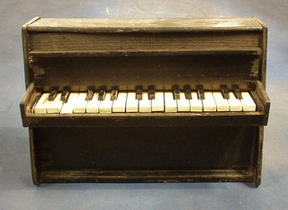 A Continental miniature upright piano contained in an ebonised case 17"