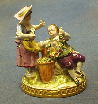 A Continental porcelain figure group boy and girl with garland of flowers on an oval base 5"
