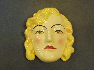 A pottery wall plaque in the form of a ladies head 7"