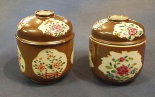 A pair of Oriental porcelain urns and covers with famille rose decorated against a brown ground, 6"