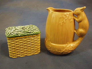 A brown glazed Sylvac pottery jug, the handle in the form of a squirrel, the base marked 1959 (ears chipped) 8" together with a Sylvac pottery teabag caddy in the form of a basket, the base marked 5038, 6" (2)