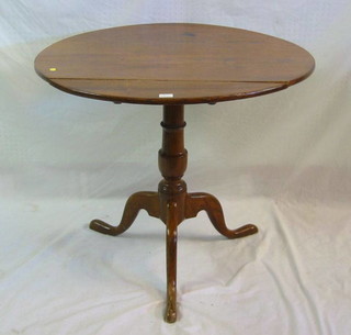 A 19th Century oak circular snap top tea table, raised on turned column and tripod supports 32"