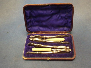 A pair of Victorian silver plated nut crackers (1f) and a pair of nut picks, cased