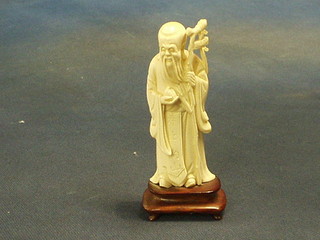 An Oriental carved ivory figure of a standing sage 4"