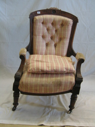 A Victorian carved walnutwood open arm chair on turned supports