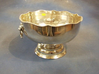 A large silver plated punch bowl with wavy border and lion mask drop handles, raised on a circular foot 12"