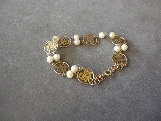An Eastern pierced gold bracelet decorated charms and interspaced pearls