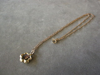 A gold chain hung a hollow gold pendant set an amethyst