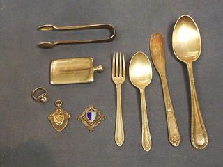 2 silver watch chain medallions, a silver ring, a silver plated scent phial, a silver teaspoon and fork, pair of silver plated tongs, butter knife and soup spoon
