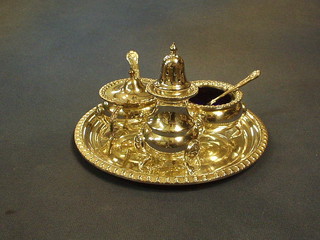 A 4 piece silver plated condiment set comprising circular tray, mustard pot, pepper pot and salt