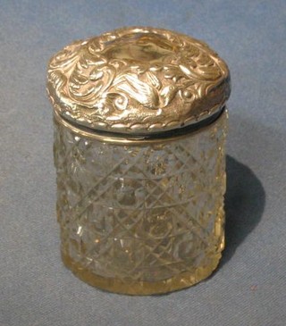 A circular cut glass dressing table jar with embossed silver lid 3 1/2"