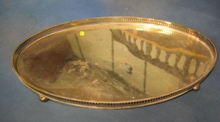 An oval silver plated galleried tea tray, raised on 4 bun feet 24"