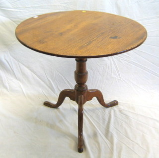 A 19th Century oak circular snap top tea table, raised on turned column and tripod supports 32"