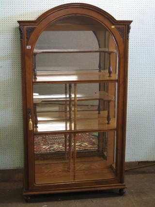 A 19th Century Continental carved walnutwood arched display cabinet with mirrored back, the interior fitted various shelves enclosed by glazed panelled doors, 38"