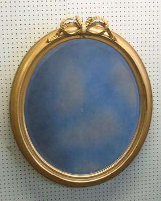 An oval bevelled plate wall mirror contained in a gilt frame surmounted by a garland 33"
