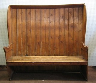 A 19th Century pine convexed winged high back settle 69"