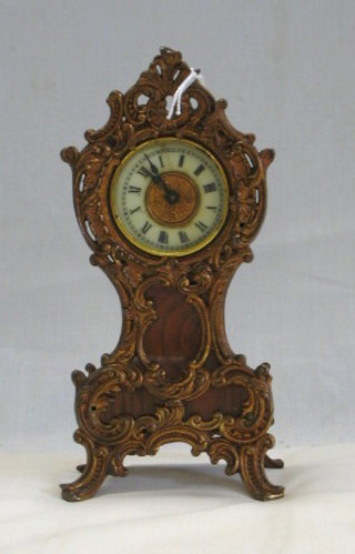 A French mantel clock with 2" circular porcelain dial with Roman numerals contained in a walnutwood and gilt mounted case 