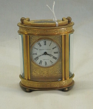 An oval carriage clock with circular enamelled dial marked Ellett & Sons London, contained in a gilt metal case 3"