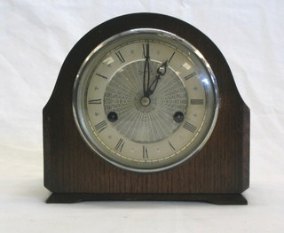 A 1950's 8 day striking mantel clock with silvered dial and arched case by Smiths