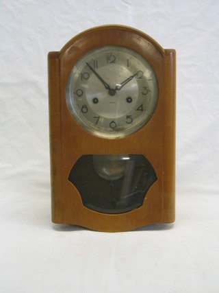 A 14 day striking wall clock with silvered dial contained in a walnutwood case