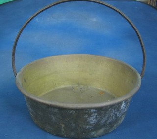 A circular brass preserving pan with iron handle 17"
