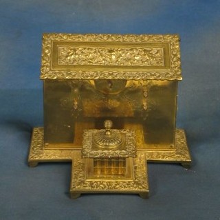A 19th Century brass standish incorporating a stationery box with hinged lid, the base fitted an inkwell, raised on bracket feet, 9"