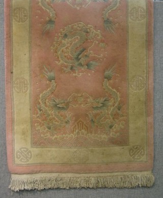 A pink coloured and floral patterned Chinese rug