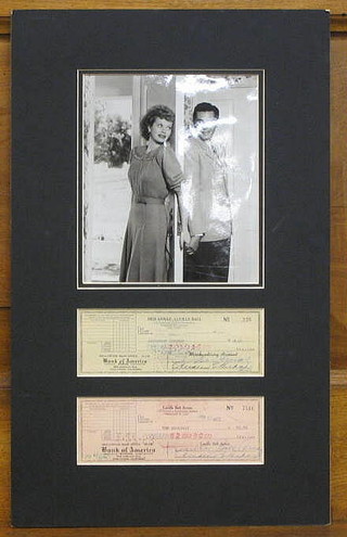 A black and white photograph of Lucille Ball and Desi Arnaz together with 2 cheques dated 19th January 1953 from the Bank of America National Trust and Association Savings Pay The Broadway $52.80 and for Desi Arnaz a cheque from the Bank of America National Trust and Association Savings Pay Restaurant Dubonnet $26.16 (undated)