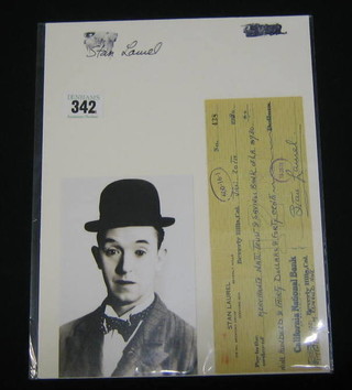 A black and white portrait photograph of Stan Laurel together with a California National Bank cheque no. 438 Stan Laurel 718 Bedford Drive, Oxford, Beverly Hills, dated January 20th 1930, Pay Merchants Natl. Trust & Savings Bank of LA $940.40 signed Stan Laurel