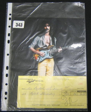 A colour portrait photograph of Frank Zappa with guitar together with a Crocker National Bank cheque Descreet 5831 Sunset Boulevard, Hollywood, California, dated 10 5 73