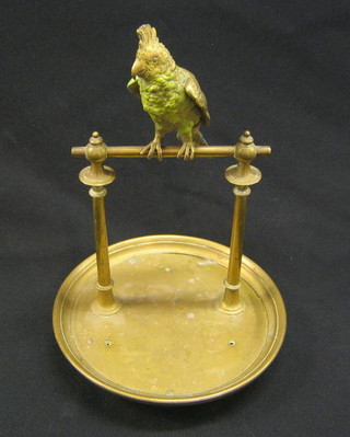 A "19th Century" silver plated watch stand in the form of a parrot sat on a perch, raised on a circular base 12"