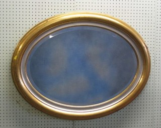 An oval bevelled plate wall mirror contained in a decorative gilt frame 32"