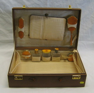 A 1950's fitted leather vanity case with clothes brush, hair brush, 5 bottles with yellow enamel